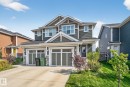 Craftsman-style house featuring driveway, stone siding, a garage, and a front yard - 211 Sturtz Bend, Leduc, AB  - Outdoor With Facade 