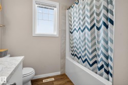 Full bathroom with vanity, wood finished floors, and shower / bathtub combination with curtain - 