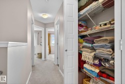 Hall featuring light colored carpet and a textured ceiling - 