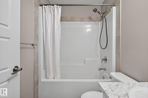 Full bathroom with vanity, shower / tub combo, and a textured ceiling - 211 Sturtz Bend, Leduc, AB - Indoor Photo Showing Bathroom