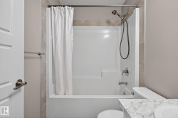Full bathroom with vanity, shower / tub combo, and a textured ceiling - 