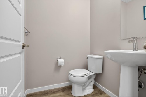 Half bathroom with toilet and light wood-style flooring - 211 Sturtz Bend, Leduc, AB - Indoor Photo Showing Bathroom