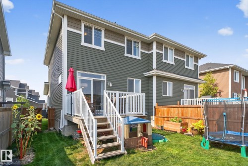 Rear view of property with a trampoline and a fenced backyard - 211 Sturtz Bend, Leduc, AB - Outdoor