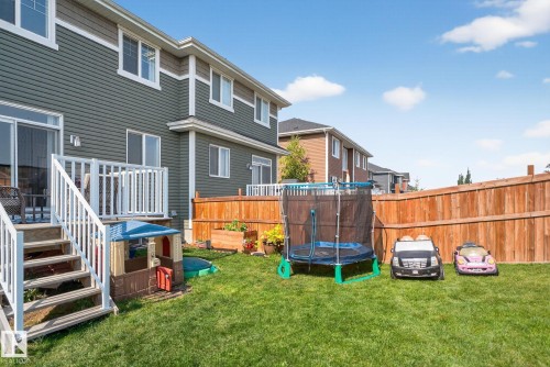 Fenced backyard with a trampoline and a deck - 211 Sturtz Bend, Leduc, AB - Outdoor