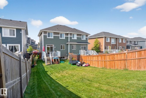 Back of house featuring a residential view, a fenced backyard, and a wooden deck - 211 Sturtz Bend, Leduc, AB - Outdoor