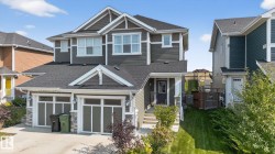 Craftsman-style house featuring a shingled roof, stone siding, and a front yard - 