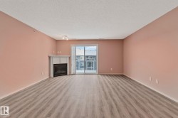 Unfurnished living room with light wood-type flooring, a fireplace, and a textured ceiling - 