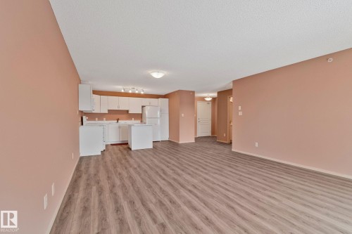 Unfurnished living room featuring light wood-type flooring and baseboards - 406 16035 132 Street Nw, Edmonton, AB - Indoor
