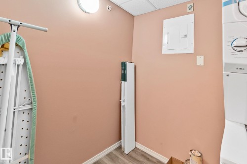 Detailed view of a paneled ceiling, electric panel, wood finished floors, and washer / clothes dryer - 406 16035 132 Street Nw, Edmonton, AB - Indoor