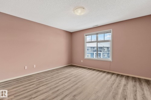 Unfurnished room featuring light wood-style flooring and a textured ceiling - 406 16035 132 Street Nw, Edmonton, AB - Indoor Photo Showing Other Room