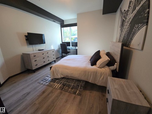 Bedroom featuring an office area and dark wood finished floors - 106 10531 117 Street, Edmonton, AB - Indoor Photo Showing Bedroom