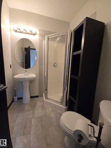 Bathroom with toilet and a stall shower - 106 10531 117 Street, Edmonton, AB - Indoor Photo Showing Bathroom