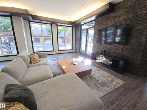 Living room with wood finished floors - 106 10531 117 Street, Edmonton, AB - Indoor Photo Showing Living Room With Fireplace