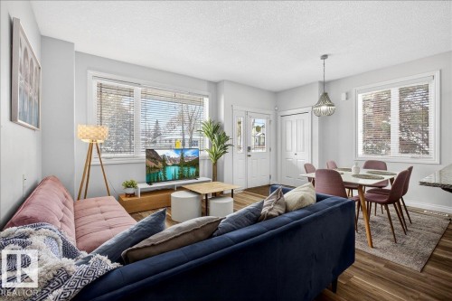 Living area featuring a textured ceiling and wood finished floors - 12761 119 St, Edmonton, AB - Indoor Photo Showing Living Room