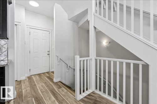 Stairway with wood finished floors and baseboards - 12761 119 St, Edmonton, AB - Indoor Photo Showing Other Room