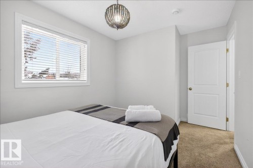 Bedroom with light carpet and baseboards - 12761 119 St, Edmonton, AB - Indoor Photo Showing Bedroom