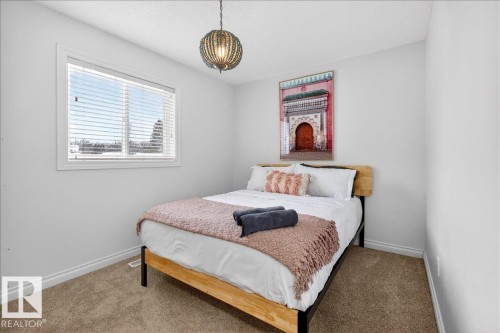 Carpeted bedroom featuring baseboards and a textured ceiling - 12761 119 St, Edmonton, AB - Indoor Photo Showing Bedroom