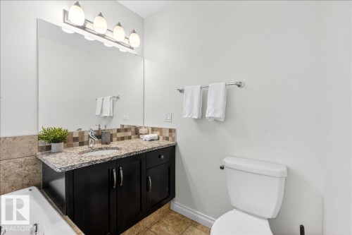 Bathroom with vanity, a garden tub, and backsplash - 12761 119 St, Edmonton, AB - Indoor Photo Showing Bathroom
