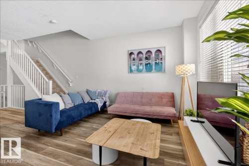 Living area featuring wood finished floors and a textured ceiling - 12761 119 St, Edmonton, AB - Indoor Photo Showing Other Room