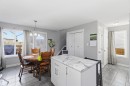 Kitchen with white cabinets, decorative light fixtures, a kitchen island, and light tile patterned flooring - 3908 161 Avenue Nw, Edmonton, AB  - Indoor Photo Showing Dining Room 