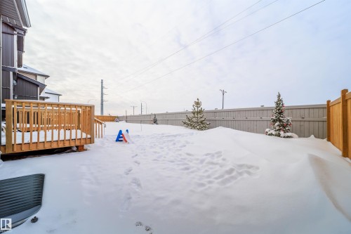 Snowy yard featuring a wooden deck and a fenced backyard - 15 Chambery Crescent, St. Albert, AB - Outdoor With Exterior