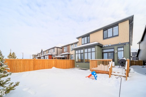 Snow covered property with a sunroom, a residential view, and a wooden deck - 15 Chambery Crescent, St. Albert, AB - Outdoor