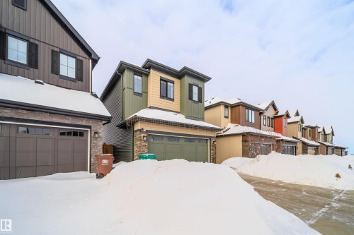 View of front of home with a residential view, stone siding, and board and batten siding - 15 Chambery Crescent, St. Albert, AB - Outdoor