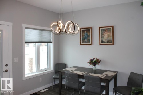 Dining room with dark wood-style flooring and a chandelier - 22 6519 46 Street, Wetaskiwin, AB - Indoor Photo Showing Dining Room