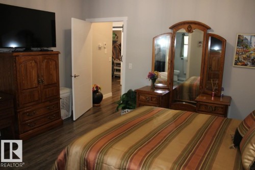 Bedroom with dark wood-style floors and ensuite bath - 22 6519 46 Street, Wetaskiwin, AB - Indoor