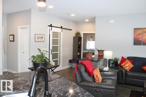 Living area with a barn door, wood finished floors, and recessed lighting - 22 6519 46 Street, Wetaskiwin, AB - Indoor Photo Showing Living Room