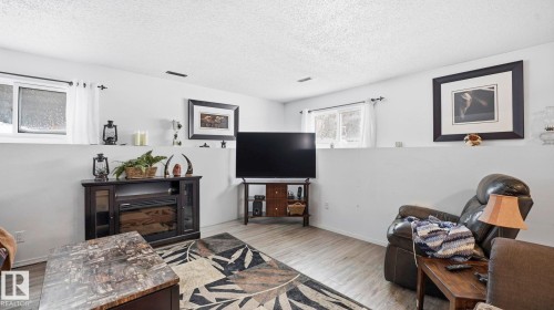 Living room featuring a textured ceiling and wood finished floors - 4502 50A Avenue, Beaumont, AB - Indoor