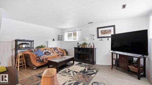 Living room with a textured ceiling and wood finished floors - 4502 50A Avenue, Beaumont, AB - Indoor Photo Showing Living Room
