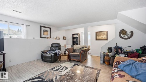 Living room featuring wood finished floors and a textured ceiling - 4502 50A Avenue, Beaumont, AB - Indoor Photo Showing Living Room