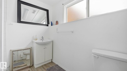 Half bath with vanity and light wood finished floors - 4502 50A Avenue, Beaumont, AB - Indoor Photo Showing Bathroom