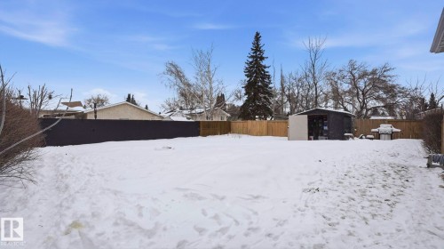 Yard layered in snow with a fenced backyard and a storage unit - 4502 50A Avenue, Beaumont, AB - Outdoor