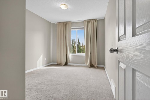 Spare room featuring light colored carpet and a textured ceiling - 1717 Chapman Way, Edmonton, AB - Indoor Photo Showing Other Room