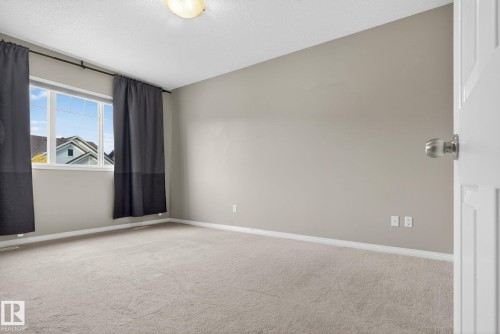 Carpeted spare room featuring a textured ceiling - 1717 Chapman Way, Edmonton, AB - Indoor Photo Showing Other Room