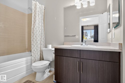 Bathroom with shower / bath combo with shower curtain, vanity, and light wood-style flooring - 1717 Chapman Way, Edmonton, AB - Indoor Photo Showing Bathroom