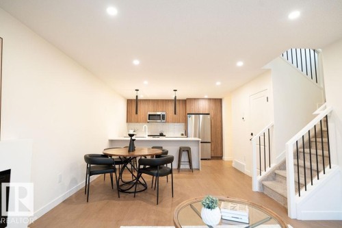 Dining area with light wood finished floors, recessed lighting, and a fireplace - 11738 91 Street Nw, Edmonton, AB - Indoor