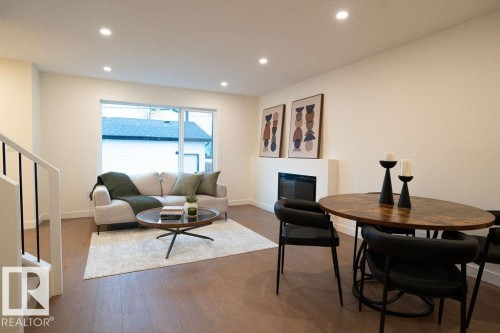 Dining space featuring a glass covered fireplace, wood finished floors, and recessed lighting - 11738 91 Street Nw, Edmonton, AB - Indoor