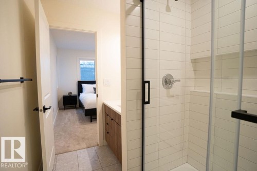 Ensuite bathroom featuring a stall shower, vanity, light carpet, and light tile patterned flooring - 11738 91 Street Nw, Edmonton, AB - Indoor Photo Showing Bathroom
