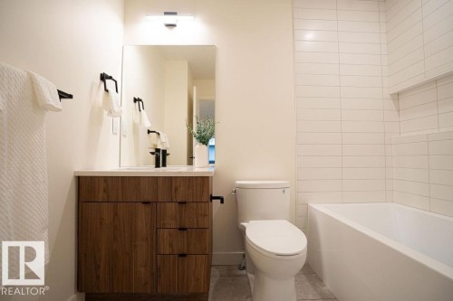 Bathroom featuring vanity, light tile patterned floors, and  shower combination - 11738 91 Street Nw, Edmonton, AB - Indoor Photo Showing Bathroom