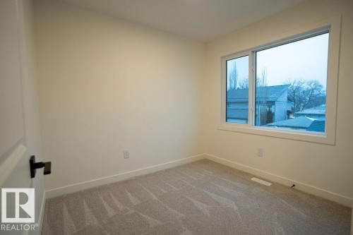 Spare room featuring baseboards and light carpet - 11738 91 Street Nw, Edmonton, AB - Indoor Photo Showing Other Room