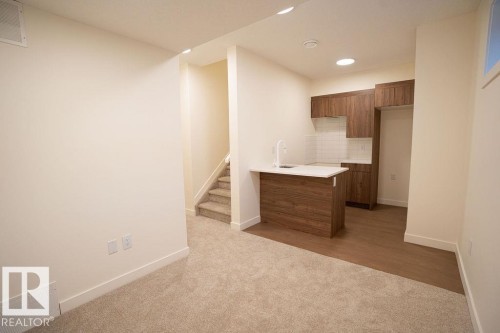 Kitchen featuring a peninsula, wood finish cabinets, light carpet, tasteful backsplash, and recessed lighting - 11738 91 Street Nw, Edmonton, AB - Indoor