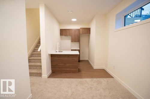 Bar area with wood finish cabinetry, light colored carpet, recessed lighting, modern cabinets, and decorative backsplash - 11738 91 Street Nw, Edmonton, AB - Indoor