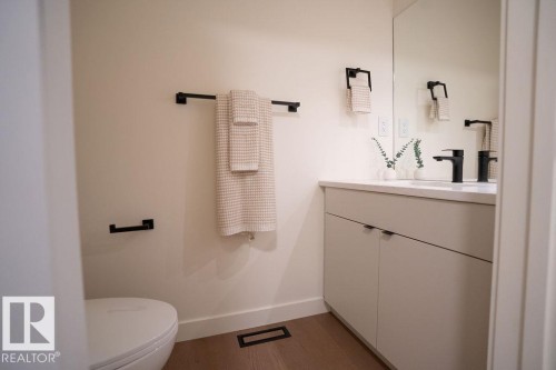 Half bathroom featuring vanity and dark wood-type flooring - 11738 91 Street Nw, Edmonton, AB - Indoor Photo Showing Bathroom