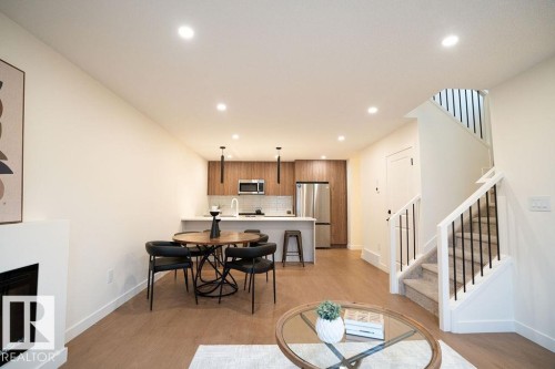 Dining room featuring light wood-style flooring, a glass covered fireplace, and recessed lighting - 11738 91 Street Nw, Edmonton, AB - Indoor Photo Showing Living Room