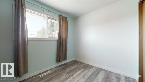Empty room with light wood-type flooring and baseboards - 4706 53 St, Leduc, AB - Indoor Photo Showing Other Room