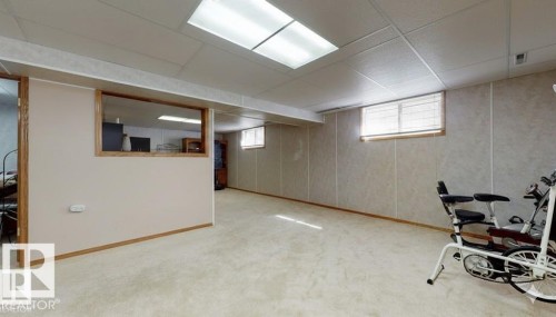 Workout room with carpet floors and a drop ceiling - 4706 53 St, Leduc, AB - Indoor Photo Showing Basement