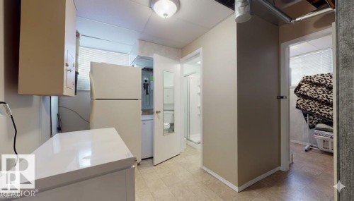 Kitchen with freestanding refrigerator, light countertops, and light flooring - 4706 53 St, Leduc, AB - Indoor